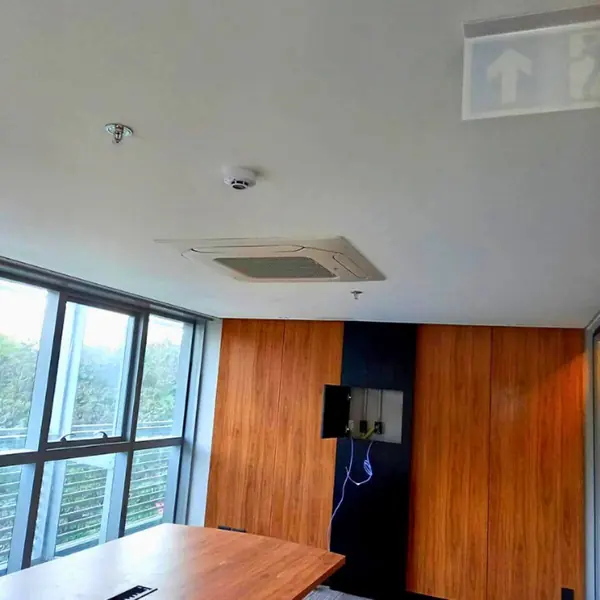 Sala com grandes vãos de vidro e cassete VRF no teto